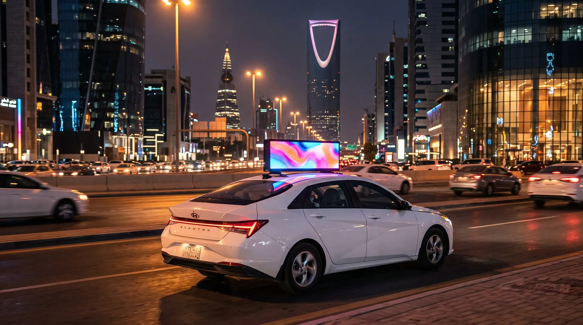 Taxi with a rooftop LED display driving through Riyadh at night