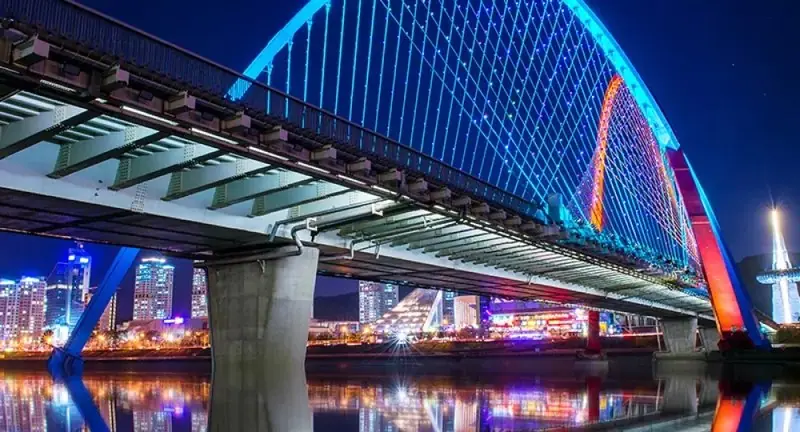 Bridge lit with coloured linear lighting at night