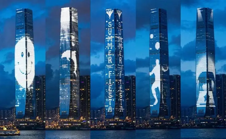 Towers wrapped in media façade content at night