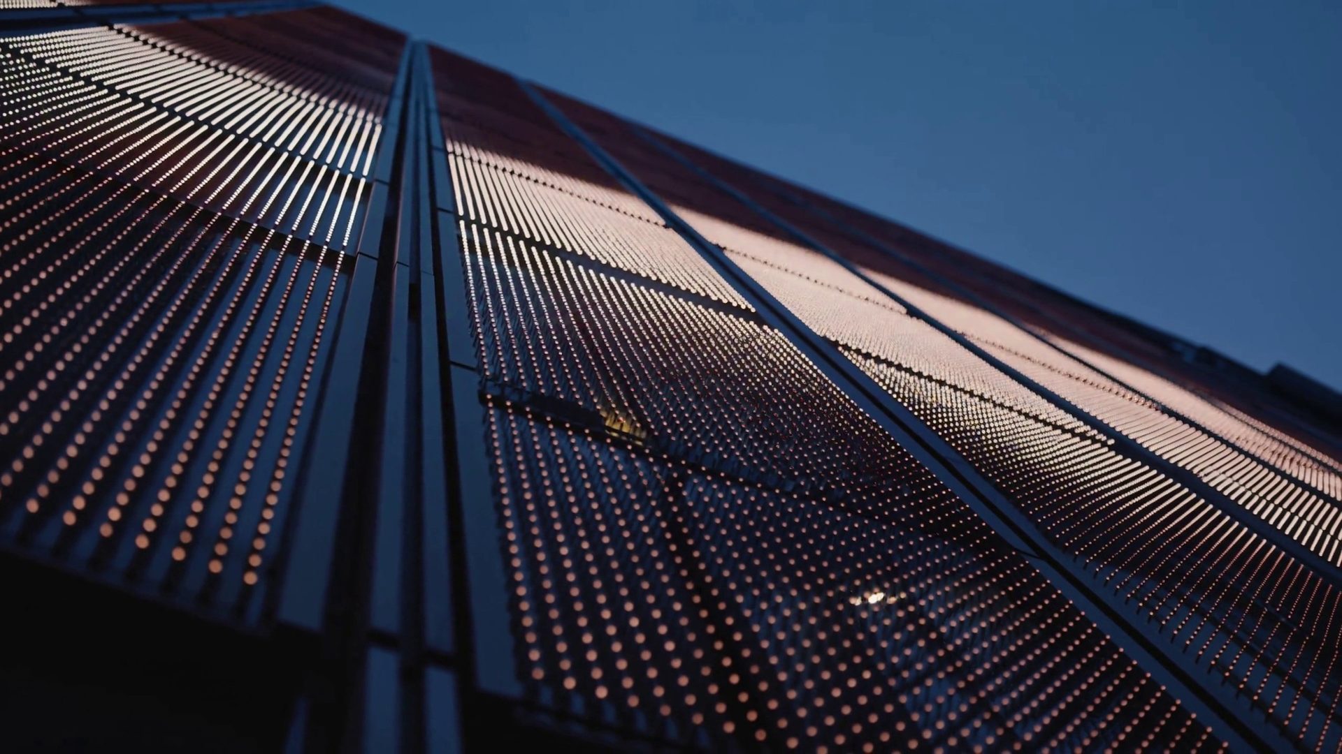 LED media facade at dusk, a band of light travelling across its pixels